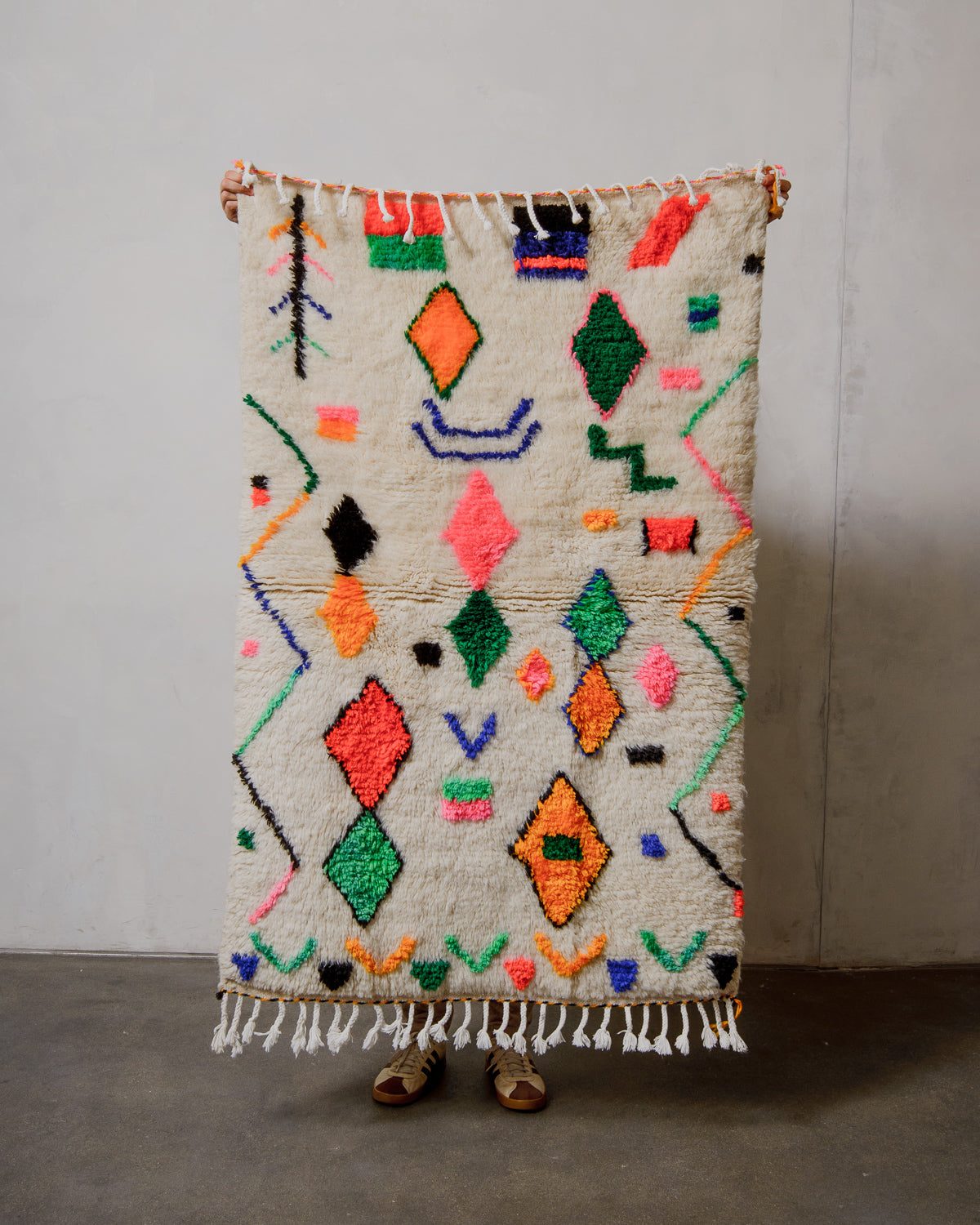 Colorful geometric patterned azilal rug on a plain background